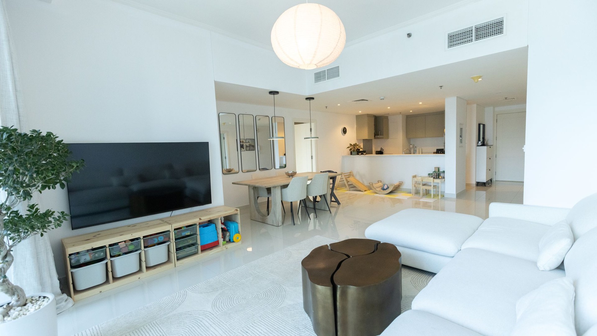Mississauga Tower — A backlit stone headboard and a mirrored bar, in an apartment where every warm surface had to be added.