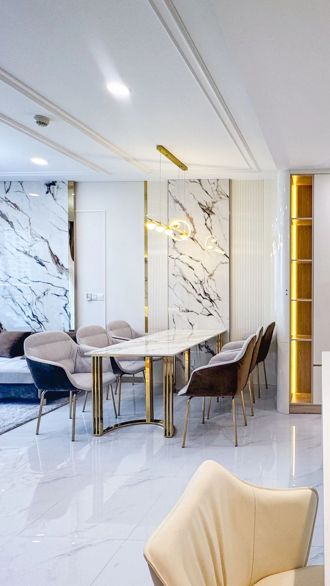 Integrated living room with illuminated shelving, marble and custom seating